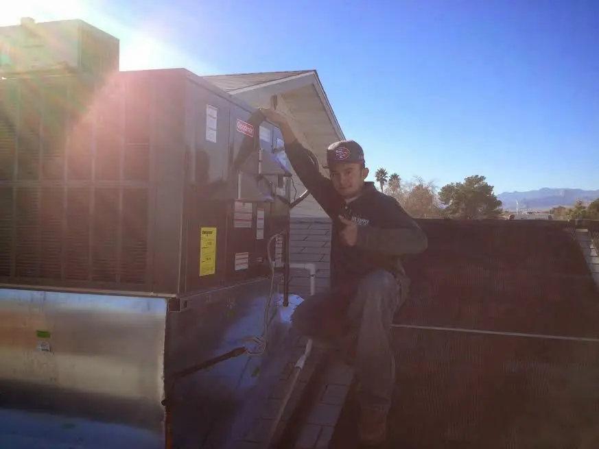 HVAC technician performing HVAC Inspection on a rooftop unit in Frankfort